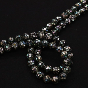 Macro shot of natural black mop mosaic shell beads with iridescent pearl texture