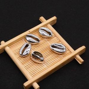 Polished silver electroplated natural cowrie shell beads on bamboo display stand