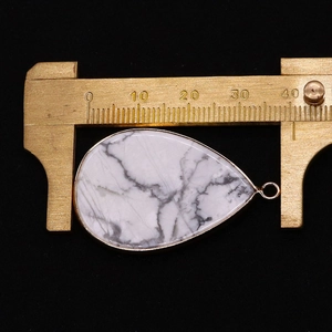 Détail du pendentif goutte avec veines grises montrant la largeur sur un pied à coulisse