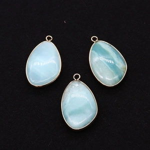 Gedetailleerd macrobeeld van druppelvormige larimar hangers met gouden metalen frames