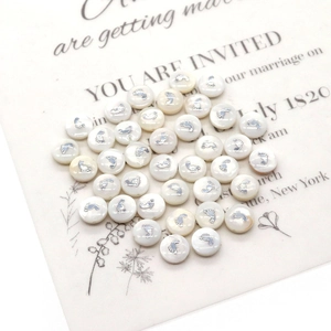 Macro detail of white pearl beads with silver baby feet for DIY jewelry making