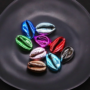 Macro detail of electroplated cowrie shells in assorted metallic colors for DIY jewelry