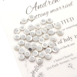 Macro shot of 6mm white shell beads with silver tree of life pattern for DIY jewelry