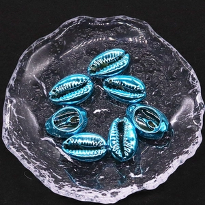 Makroaufnahme von 18-20mm galvanisierten blauen Muschelperlen für DIY-Halsketten im Glasteller