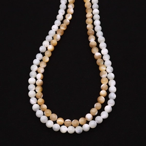 Macro detail of natural shell beads showing iridescent texture and 6-8mm polished round shape