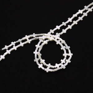 Vue détaillée de perles croix en nacre naturelle blanche pour création de bijoux