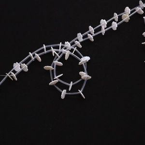 Detailed macro view of 11mm white natural freshwater shell beads with radial textures for DIY