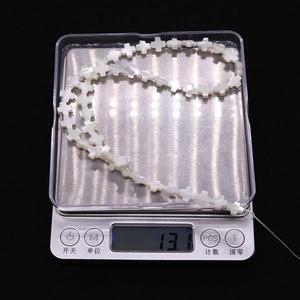 Vue détaillée de perles en nacre blanche en forme de croix pesant 13,1 grammes