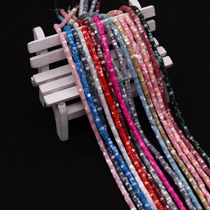 Multi-color cylindrical natural shell beads for DIY jewelry making on white bench