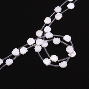 Macro shot of 12mm white natural freshwater shell beads in scallop shape with ribbed texture