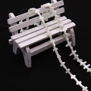 Perles en croix de nacre blanche naturelle disposées sur un petit banc décoratif blanc