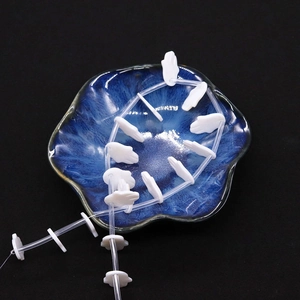 Natural white shell beads in hand shape for DIY jewelry making on a ceramic plate