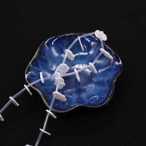 Macro detail of white Hamsa Hand shell beads displayed on a blue ceramic plate