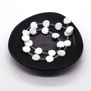 Natural white shell fan-shaped beads for DIY jewelry making on a black tray