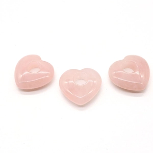 Détail macro de trois perles cœur en quartz rose à gros trous pour bijoux DIY