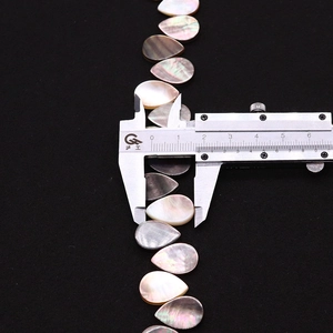 Makro-Detail natürlicher Perlmuttperlen in Tropfenform, 13mm Messung am Messschieber