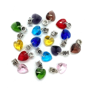 Macro shot of colorful heart-shaped faceted crystal pendants with silver floral bail connectors