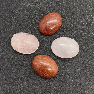 Close-up of oval pink quartz and goldstone cabochons for DIY jewelry making
