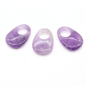 Macro detail of three purple opal gemstone pendants with natural stone textures on white base