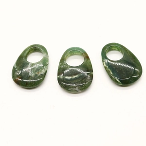Macro shot of three teardrop-shaped natural opal stone pendants with polished green texture