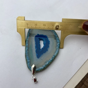 Détail montrant la mesure de la largeur d'une tranche d'agate de 41 mm au pied à coulisse