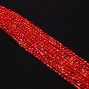 Nahaufnahme leuchtend roter 5x8mm Reisschalenperlen für DIY-Schmuckherstellung