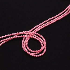Detailopname van 2mm-4mm roze schelpkralen op zwarte achtergrond voor DIY-sieraden maken
