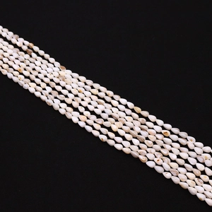 Makroaufnahme von 5x8 mm reisförmigen weißen Muschelperlen mit natürlichem Glanz