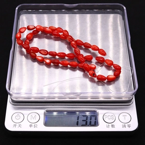 Detail von roten gefärbten Muschelperlen auf einer Waage mit 13,0g Gewicht für DIY-Schmuck