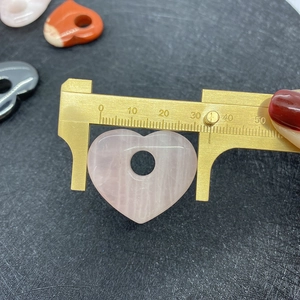 Detail van 30mm natuurstenen hartvormige hanger met meting op een schuifmaat