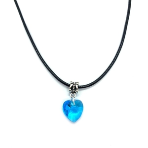 Detail of blue heart-shaped faceted crystal pendant with silver bow clasp and black cord