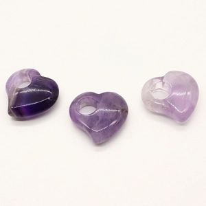 Nahaufnahme von drei lilafarbenen Amethyst-Anhängern in Herzform für DIY-Schmuck
