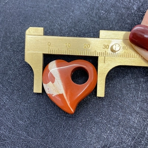 Detail van een 30mm hartvormige rode jaspis hanger met meting van het middengat