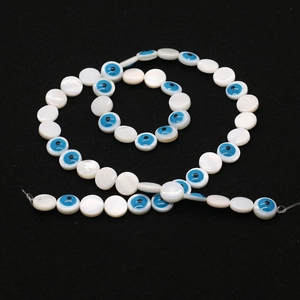 Macro detail of 6mm natural shell evil eye beads string for DIY jewelry making