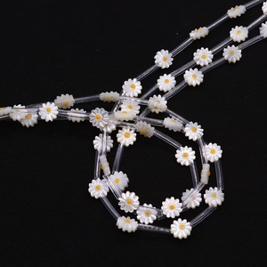 Macro shot of white daisy shell beads with yellow centers for jewelry making