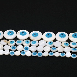 Detail of round shell evil eye beads in various sizes on a black background