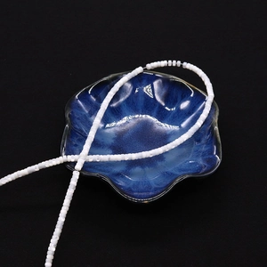 Dettaglio di perle in madreperla bianca su un piattino di ceramica blu decorato