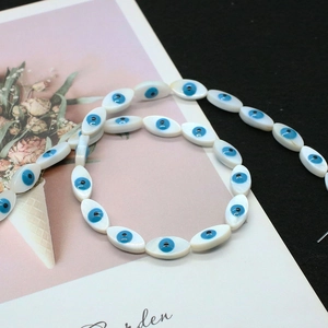 Macro detail of marquise evil eye beads made from natural mother of pearl shell