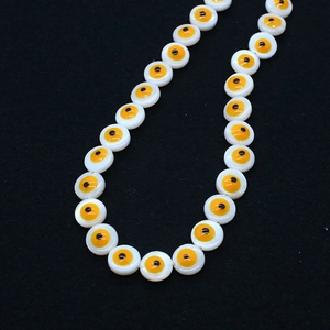 Macro detail of 9mm white shell Evil Eye beads for DIY jewelry making accessories