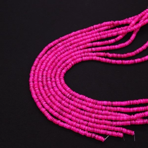 Macro-opname van felroze platte heishi-kralen strengen voor DIY-sieraden maken