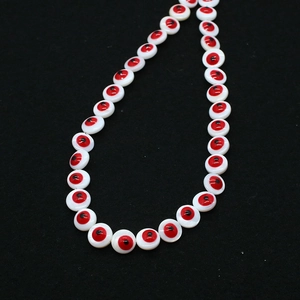 Macro detail of red shell evil eye beads for DIY jewelry making and necklaces