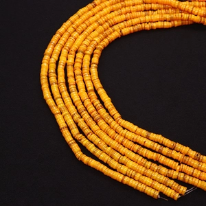 Detailopname van gele Heishi-schijfkralen op koorden voor het maken van sieraden