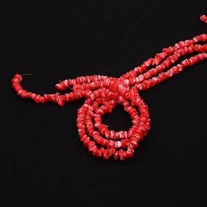 Close-up van onregelmatige rode schelpkralen met marmeren textuur voor DIY-sieraden maken