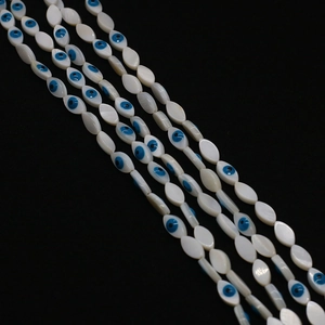 Vue détaillée de perles en nacre de forme marquise avec motifs d'œil bleu protecteur