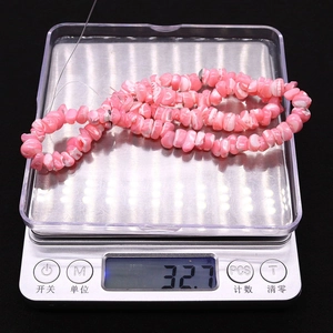 Vue détaillée de perles en coquillage rose irrégulières 7-8mm pesant 32,7g sur balance