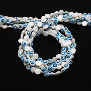 Dettaglio macro di perle occhio greco in conchiglia naturale con finitura smaltata blu