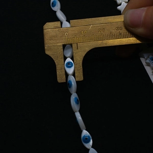 Mesure de perles en coquillage marquise de 18mm avec motif œil avec un pied à coulisse