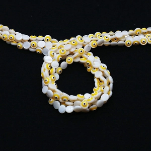 Dettaglio di perline in conchiglia 6mm-9mm con motivi malocchio per creazione di gioielli fai-da-te