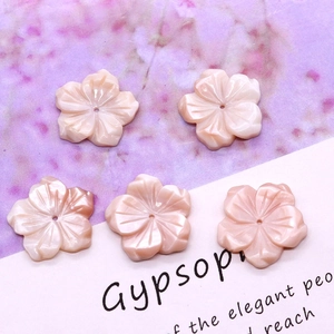 Macro detail of five-petal pink shell flower beads with shimmering pearlescent finish