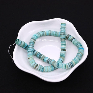 Filo di perle heishi in conchiglia blu-verde da 6-8 mm in un piattino di ceramica bianca